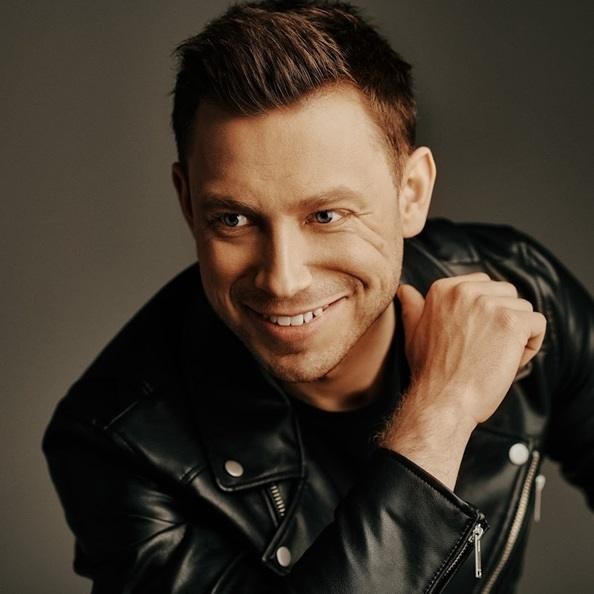 Paweł Jasionowski na scenie z zespołem Masters podczas koncertu.