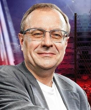 Dłonie profesora Antoniego Dudka przeglądające historyczne dokumenty i książki w gabinecie.