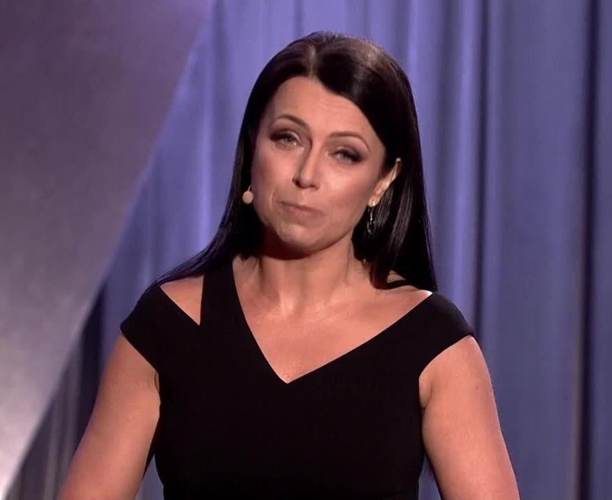 Adrianna Borek podczas występu kabaretowego, z charakterystyczną ekspresją twarzy.